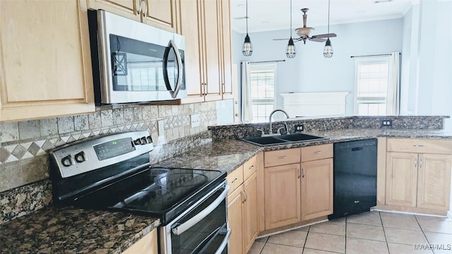 kitchen featuring ceiling fan, sink, stainless steel appliances, dark stone countertops, and pendant lighting