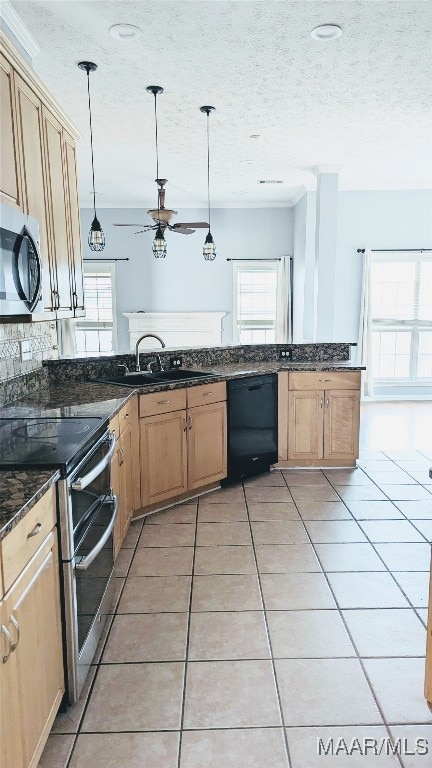 kitchen with a textured ceiling, light tile patterned flooring, stainless steel appliances, and decorative light fixtures