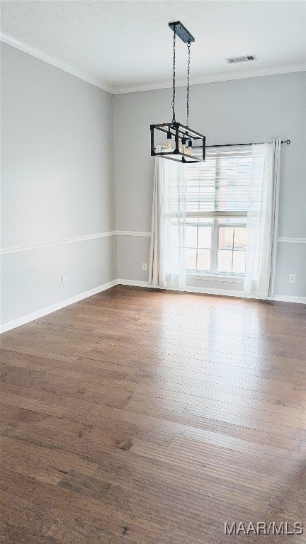 unfurnished dining area featuring ornamental molding, dark hardwood / wood-style floors, and a notable chandelier