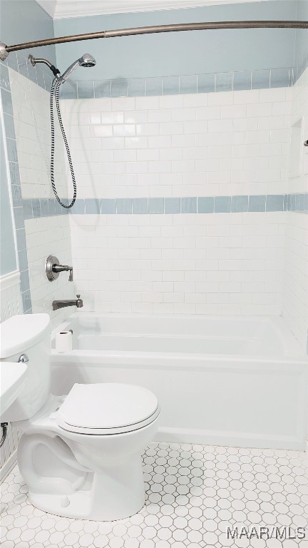 bathroom featuring toilet and tiled shower / bath