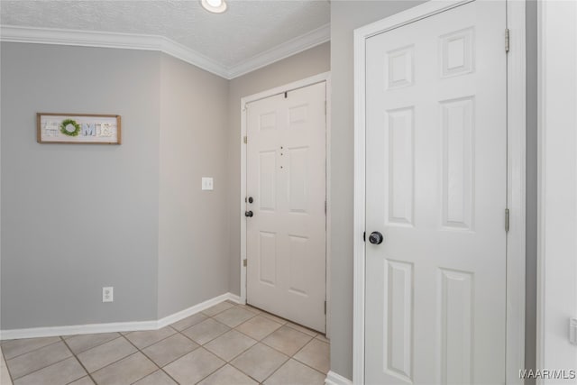 tiled foyer featuring a textured ceiling and ornamental molding