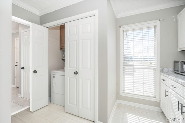 laundry room featuring cabinets, washer / clothes dryer, a wealth of natural light, and ornamental molding