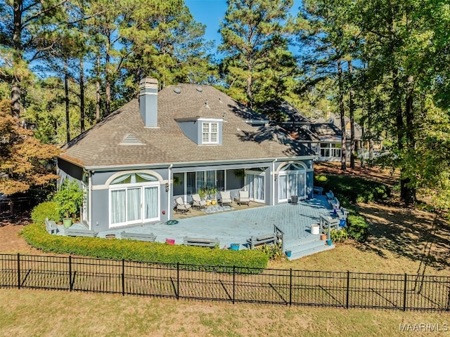 rear view of property with a deck and a lawn