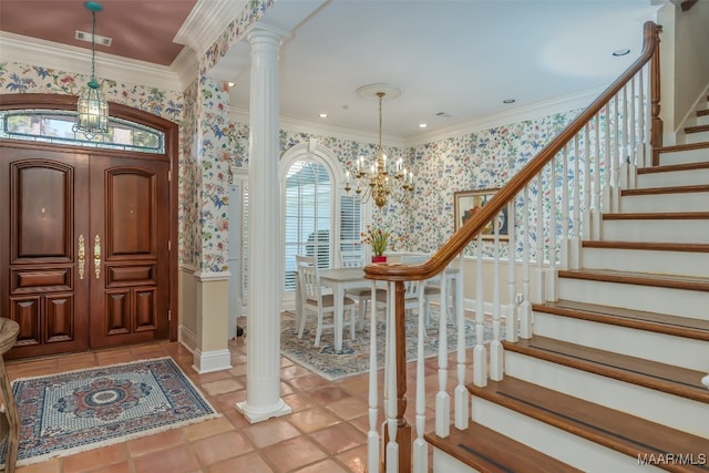 entrance foyer with a chandelier, ornate columns, and crown molding