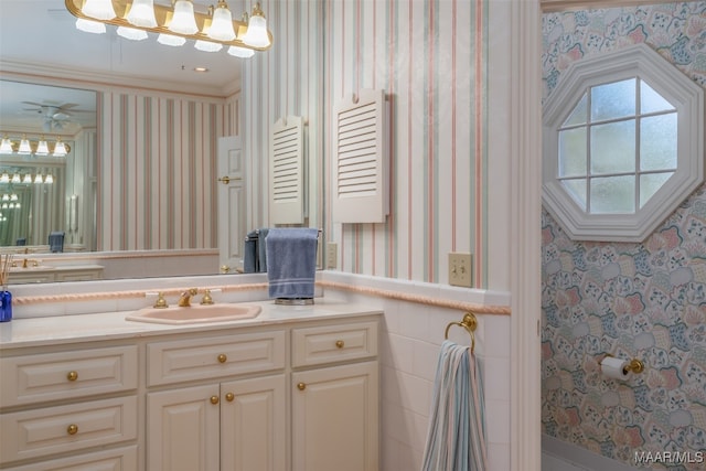 bathroom with crown molding, vanity, and ceiling fan