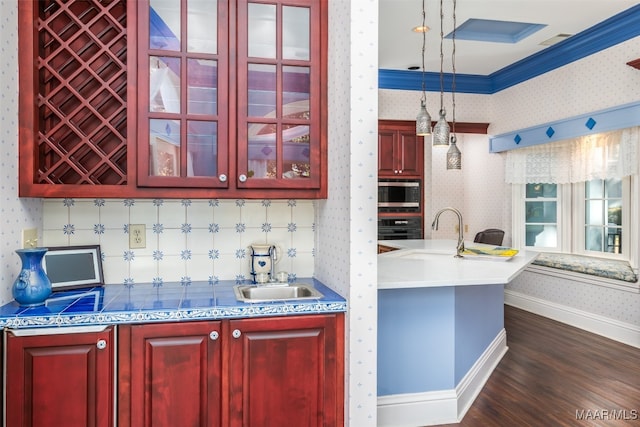 kitchen featuring sink, dark hardwood / wood-style floors, oven, pendant lighting, and ornamental molding