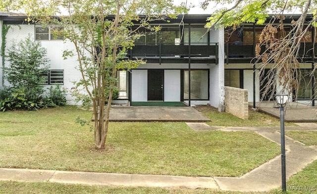 rear view of house featuring a patio and a lawn