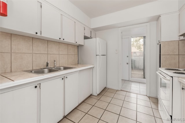 kitchen featuring white cabinetry, tile counters, sink, white appliances, and light tile patterned flooring