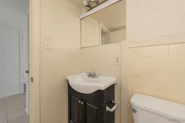 bathroom featuring tile patterned flooring, vanity, and toilet