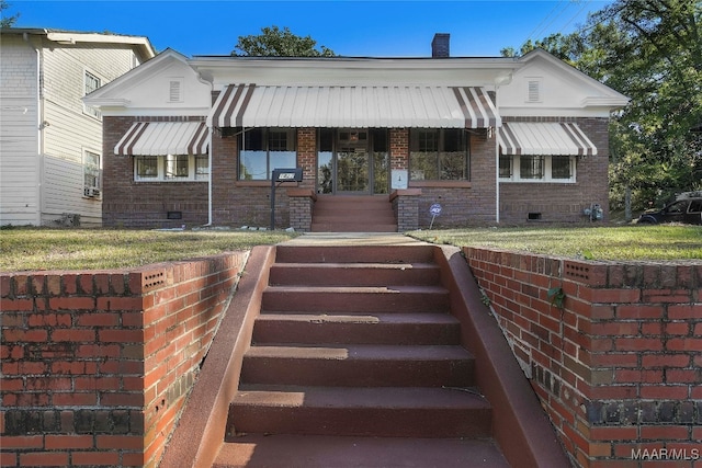 bungalow-style home featuring a front lawn