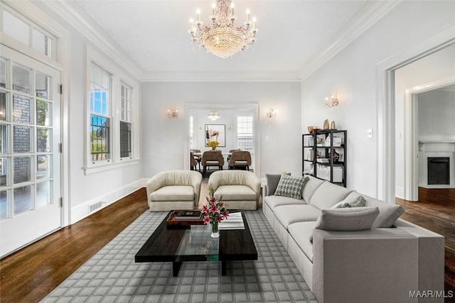 living room featuring crown molding, dark hardwood / wood-style flooring, and a notable chandelier