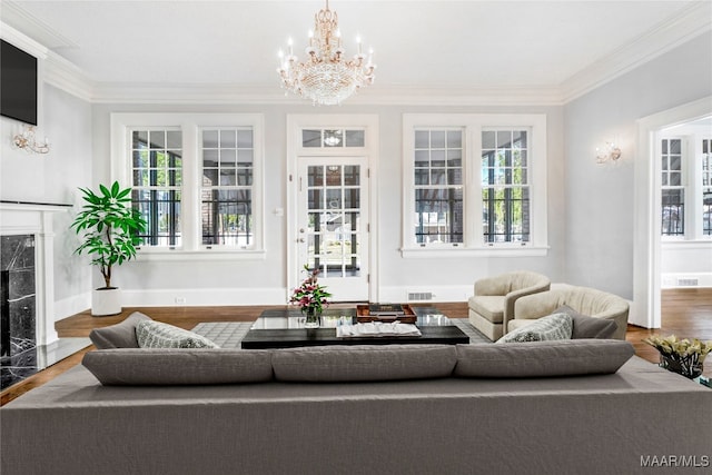 living room with hardwood / wood-style flooring, a healthy amount of sunlight, ornamental molding, and a fireplace