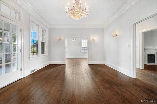 unfurnished living room featuring crown molding, dark wood-type flooring, a textured ceiling, and an inviting chandelier