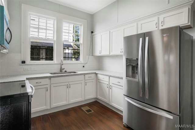 kitchen featuring appliances with stainless steel finishes, dark hardwood / wood-style flooring, light stone counters, sink, and white cabinetry