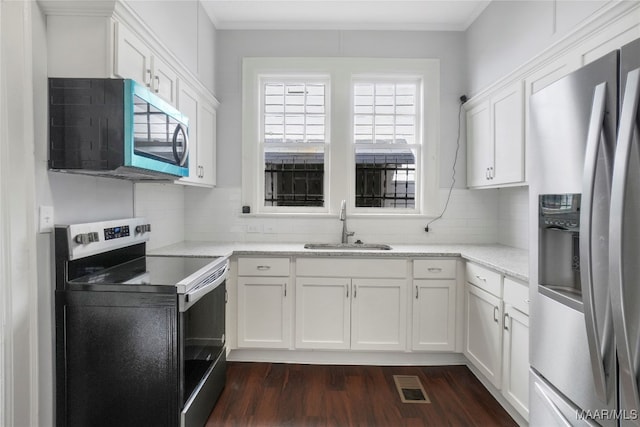 kitchen featuring white cabinets, appliances with stainless steel finishes, and sink