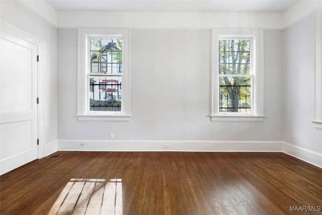 unfurnished room with a wealth of natural light and dark hardwood / wood-style floors