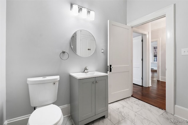 bathroom featuring wood-type flooring, vanity, and toilet