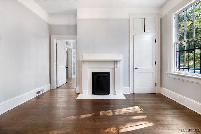 1427 S Court St, Montgomery, AL 36104 - unfurnished living room featuring healthy amount of natural light, wood finished floors, baseboards, and a tile fireplace