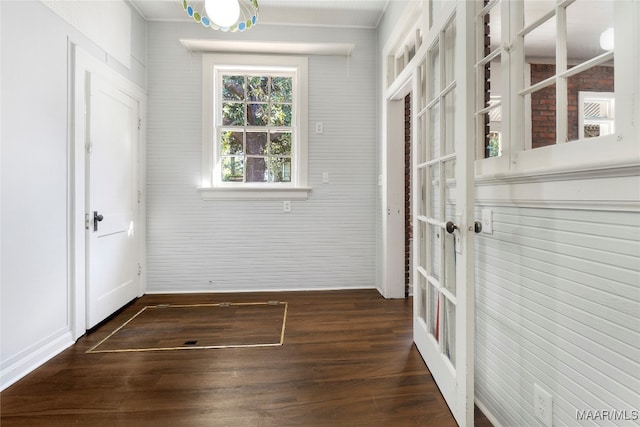 unfurnished room featuring dark hardwood / wood-style flooring and brick wall