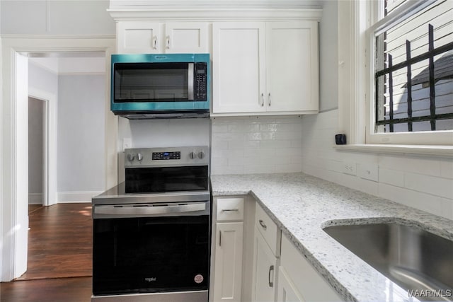 kitchen featuring white cabinetry, stainless steel appliances, and light stone counters