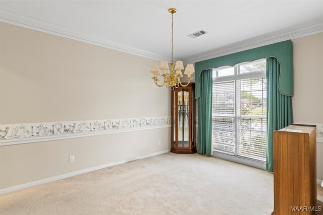 spare room with carpet flooring, ornamental molding, and a notable chandelier