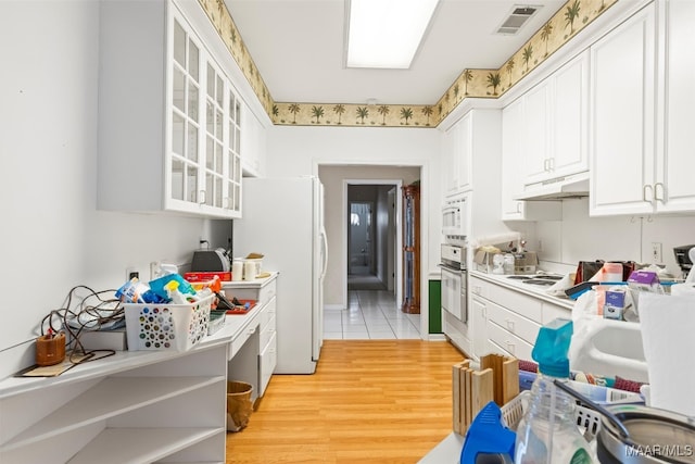 kitchen featuring white cabinets, white appliances, and light wood-type flooring