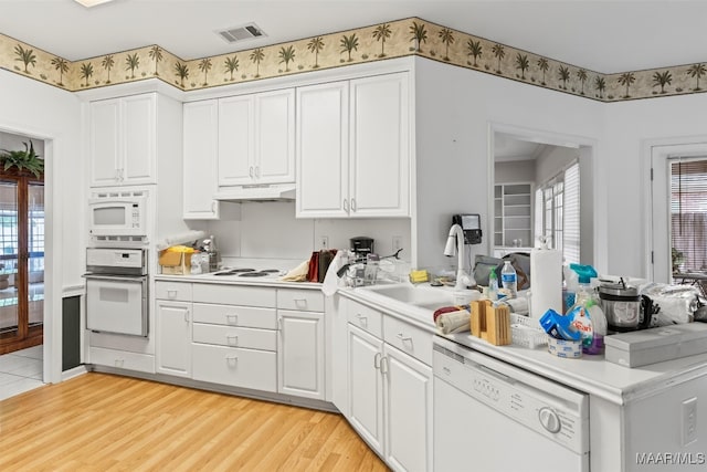 kitchen featuring white appliances, white cabinetry, light hardwood / wood-style flooring, and sink