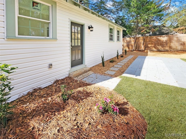 view of exterior entry with a patio area