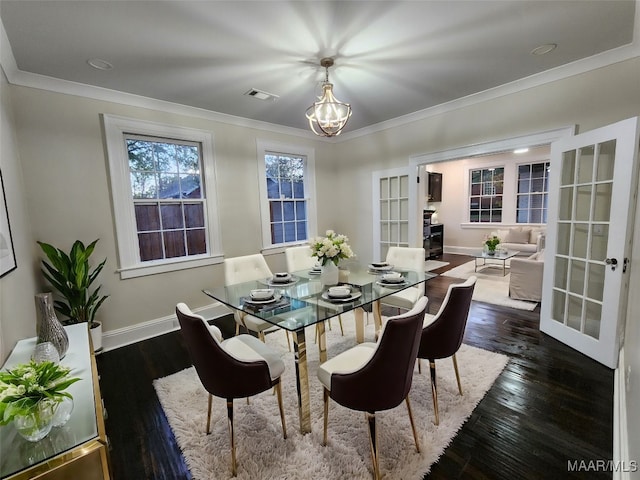 dining area with crown molding, french doors, dark hardwood / wood-style floors, and an inviting chandelier