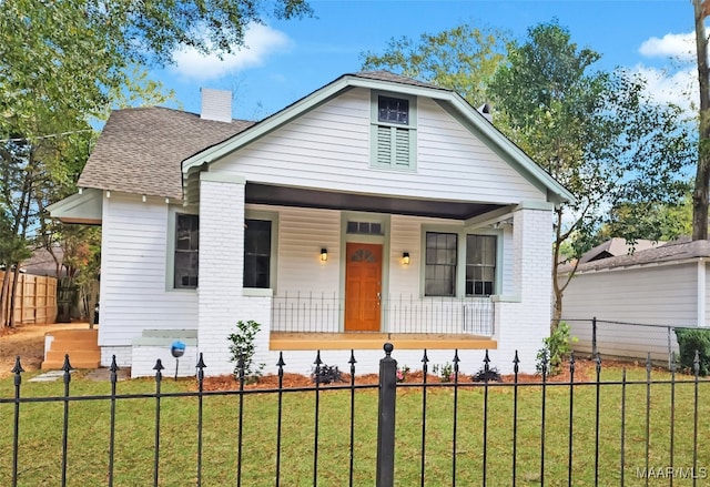 bungalow-style house with a porch and a front lawn