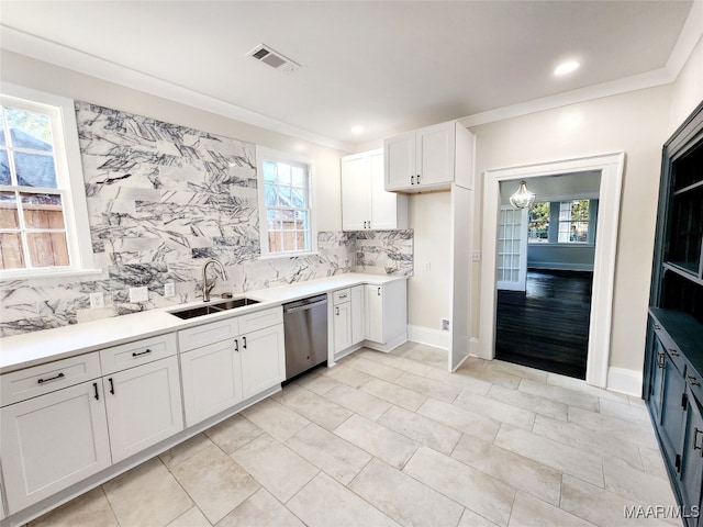 kitchen with backsplash, white cabinets, ornamental molding, sink, and dishwasher