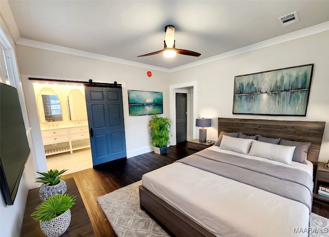 bedroom with a barn door, ceiling fan, dark hardwood / wood-style floors, and ornamental molding