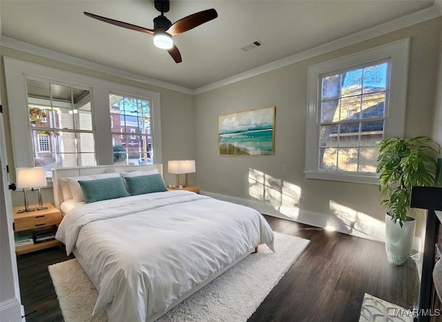 bedroom with ceiling fan, ornamental molding, and dark wood-type flooring