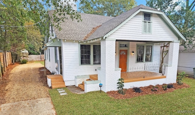 bungalow with covered porch and a front lawn