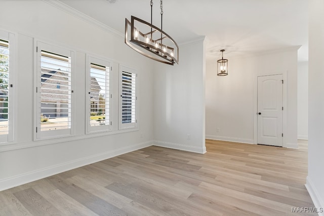 unfurnished dining area featuring crown molding, a notable chandelier, and light wood-type flooring