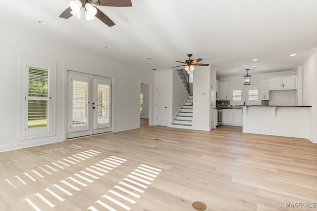 unfurnished living room with french doors and light wood-type flooring