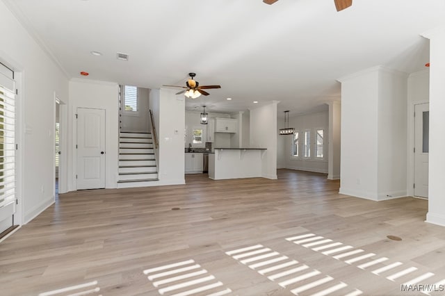 unfurnished living room featuring light hardwood / wood-style flooring, ceiling fan, crown molding, and sink