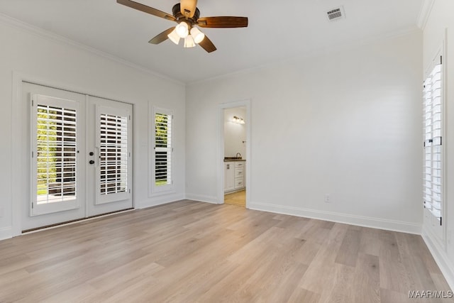 spare room with a wealth of natural light, french doors, and light hardwood / wood-style floors