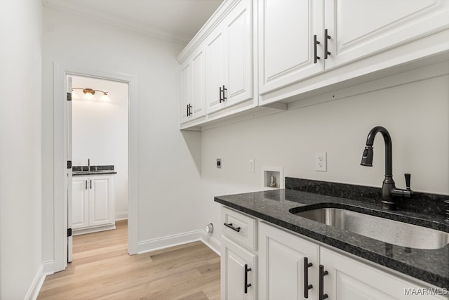 washroom with cabinets, washer hookup, electric dryer hookup, sink, and light hardwood / wood-style floors