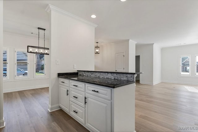 2524 Crenshaw Close Ct S, Montgomery, AL 36106 - kitchen featuring a peninsula, light wood-style flooring, a chandelier, white cabinets, and baseboards