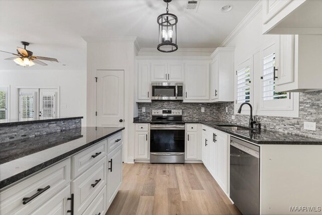 2524 Crenshaw Close Ct S, Montgomery, AL 36106 - kitchen featuring stainless steel appliances, ornamental molding, white cabinetry, a sink, and light wood-style floors
