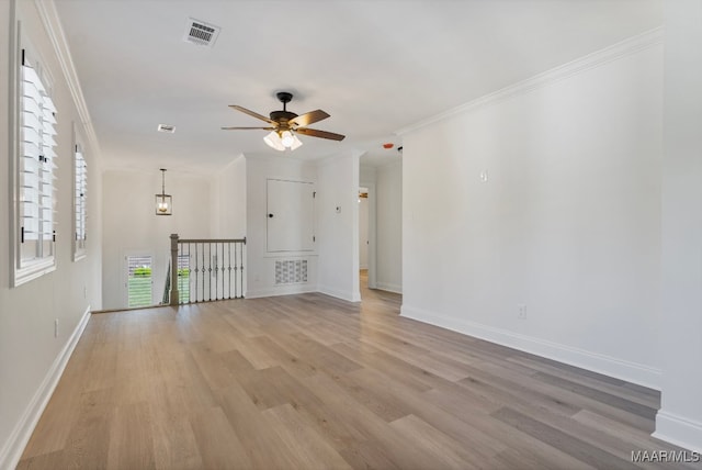 empty room featuring ceiling fan, light hardwood / wood-style flooring, and ornamental molding