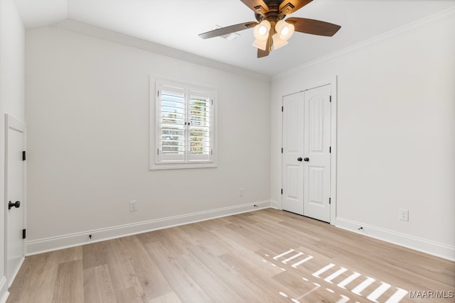 spare room with ceiling fan, light wood-type flooring, crown molding, and lofted ceiling