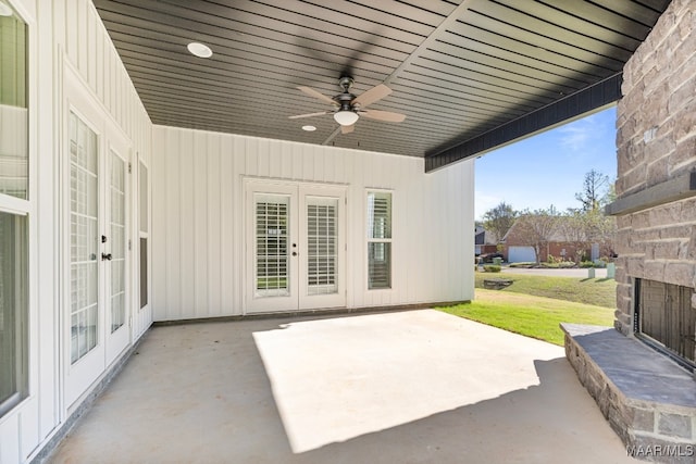 view of patio / terrace featuring an outdoor stone fireplace, ceiling fan, and french doors