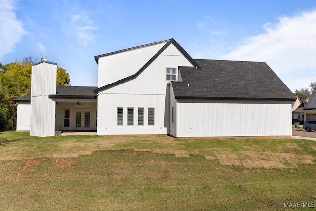 rear view of property featuring a lawn, ceiling fan, and french doors