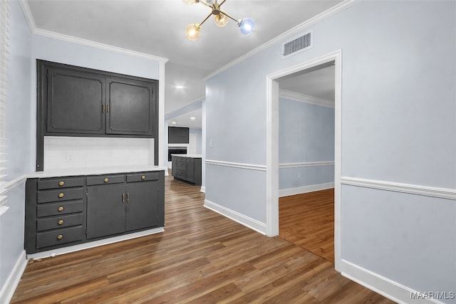 kitchen with crown molding, dark wood-type flooring, and an inviting chandelier