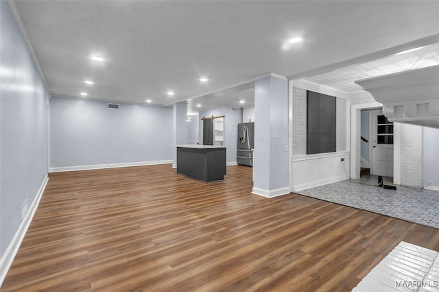 unfurnished living room with crown molding and dark wood-type flooring