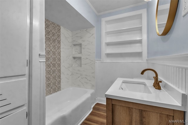 bathroom featuring hardwood / wood-style floors, vanity, crown molding, tiled shower / bath, and built in shelves