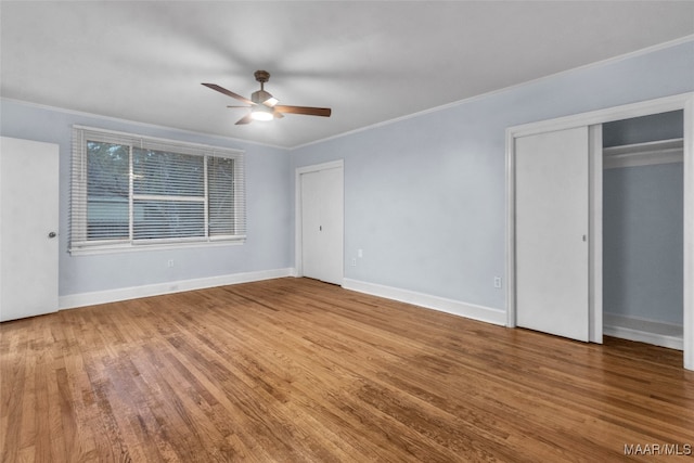 unfurnished bedroom featuring ceiling fan, wood-type flooring, and ornamental molding