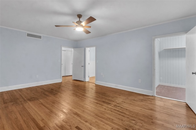 spare room with wood-type flooring, ceiling fan, and crown molding